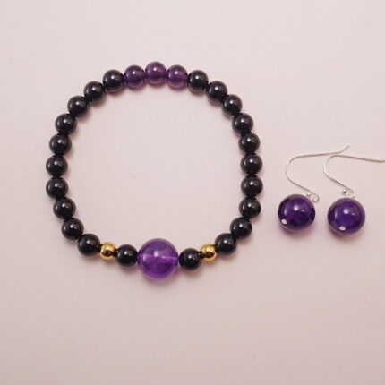 A striking set featuring a Black Obsidian Amethyst Bracelet with a gold accent bead and matching Amethyst Ball Earrings. Elegant and bold, this set enhances any outfit with its deep amethyst hues and contrasting black and gold accents.