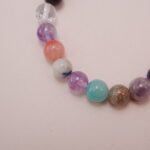 Close-up view of the multicolor gemstone bracelet with a silver accent bead, featuring a mix of healing stones.