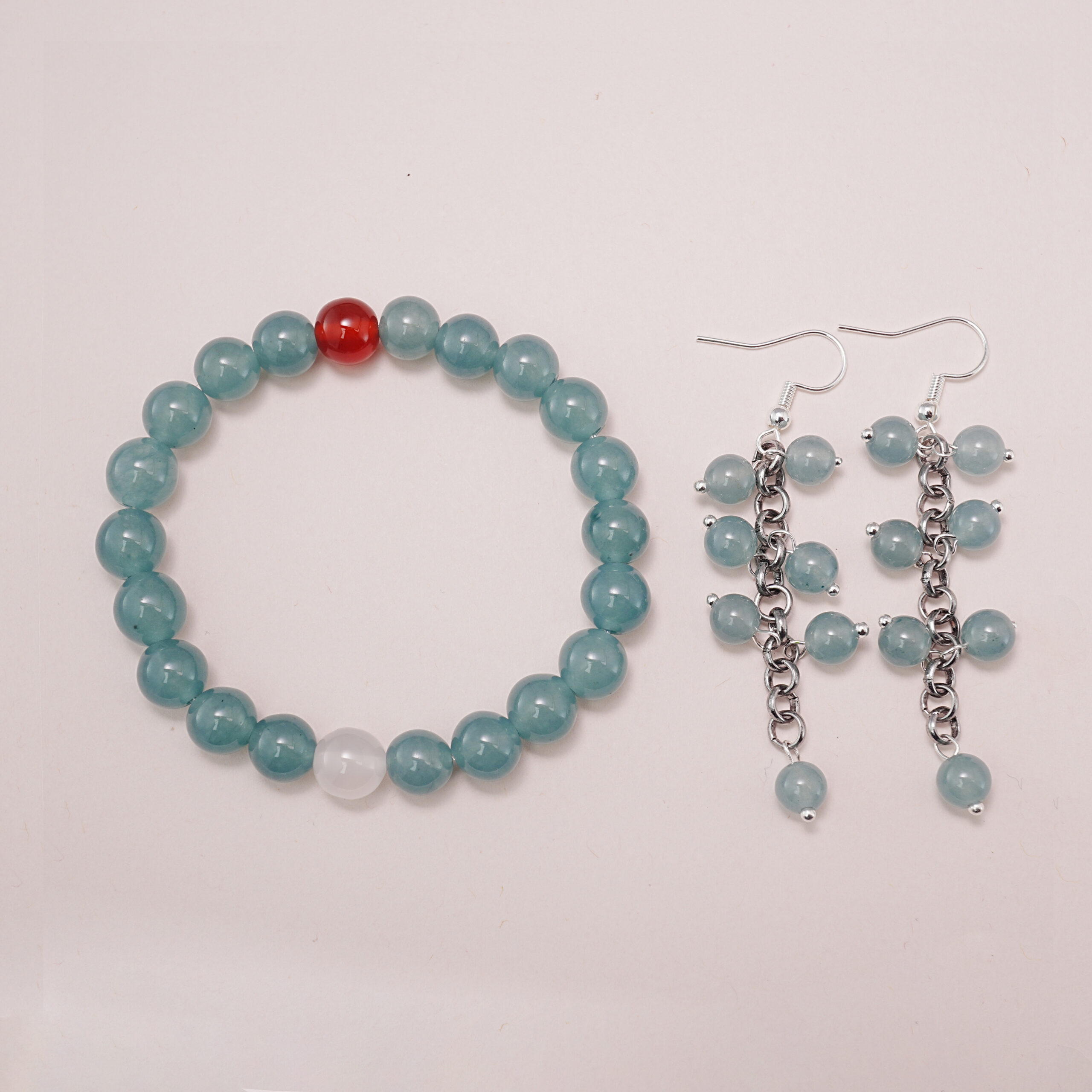 green-chalcedony-carnelian-bracelet-rose-quartz-earrings-set-main A beautiful set featuring a green chalcedony bracelet with a carnelian accent and matching green chalcedony earrings with a chain design.