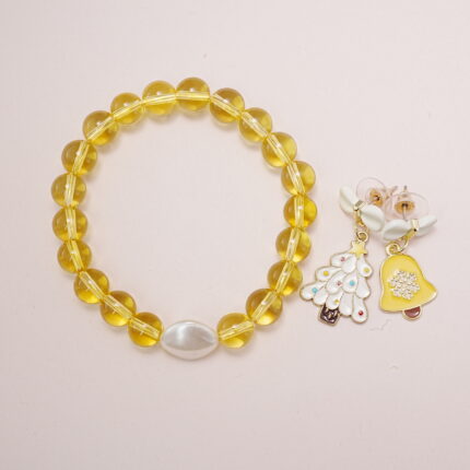 A bright yellow quartz bead bracelet with a white pearl centerpiece, paired with yellow bell and Christmas tree bow earrings.