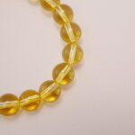 Close-up of the yellow quartz bead bracelet featuring a pearl centerpiece.