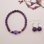 Full set of obsidian amethyst bracelet with golden beads and matching amethyst earrings, styled together