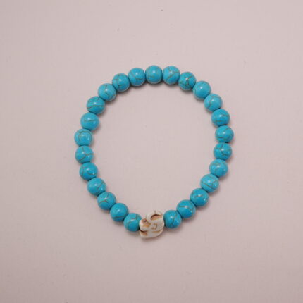 Turquoise stone bracelet with a white skull charm in the center, showcasing a simple and bold design.