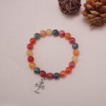 Detailed shot of the colorful chalcedony beads and the silver heart charm on the bracelet.