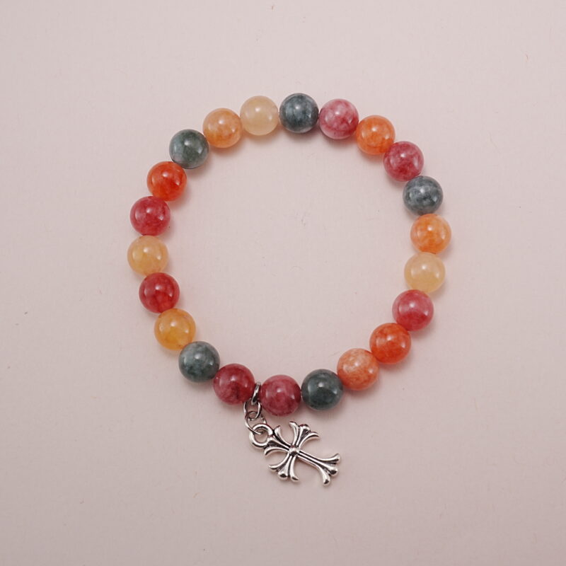 Colorful chalcedony bracelet with a silver heart charm displayed on a soft pink background.