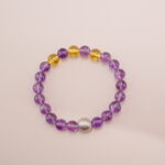 A stunning Amethyst and Citrine bracelet featuring a blend of deep purple and golden yellow gemstones, accented with a silver bead. This bracelet embodies positive energy and balance, making it perfect for bringing harmony into your life.