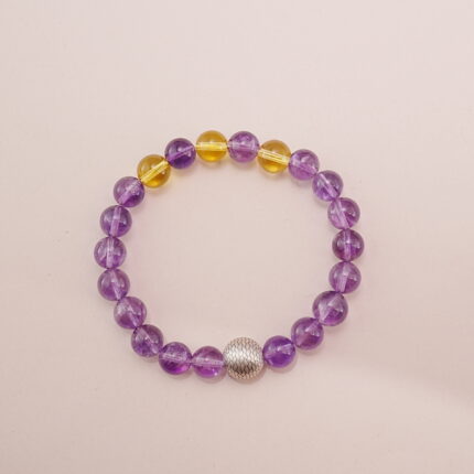 A stunning Amethyst and Citrine bracelet featuring a blend of deep purple and golden yellow gemstones, accented with a silver bead. This bracelet embodies positive energy and balance, making it perfect for bringing harmony into your life.