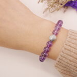A model wearing the Amethyst and Citrine bracelet on their wrist. The combination of vibrant purple and yellow gemstones creates a dynamic and balanced look that complements any style.