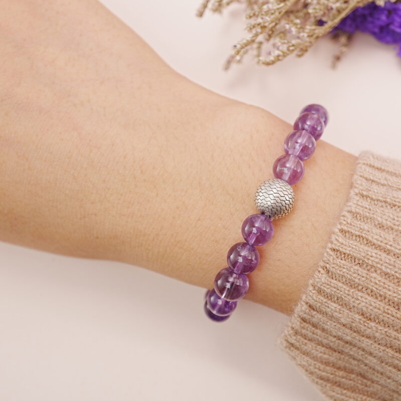 A model wearing the Amethyst and Citrine bracelet on their wrist. The combination of vibrant purple and yellow gemstones creates a dynamic and balanced look that complements any style.