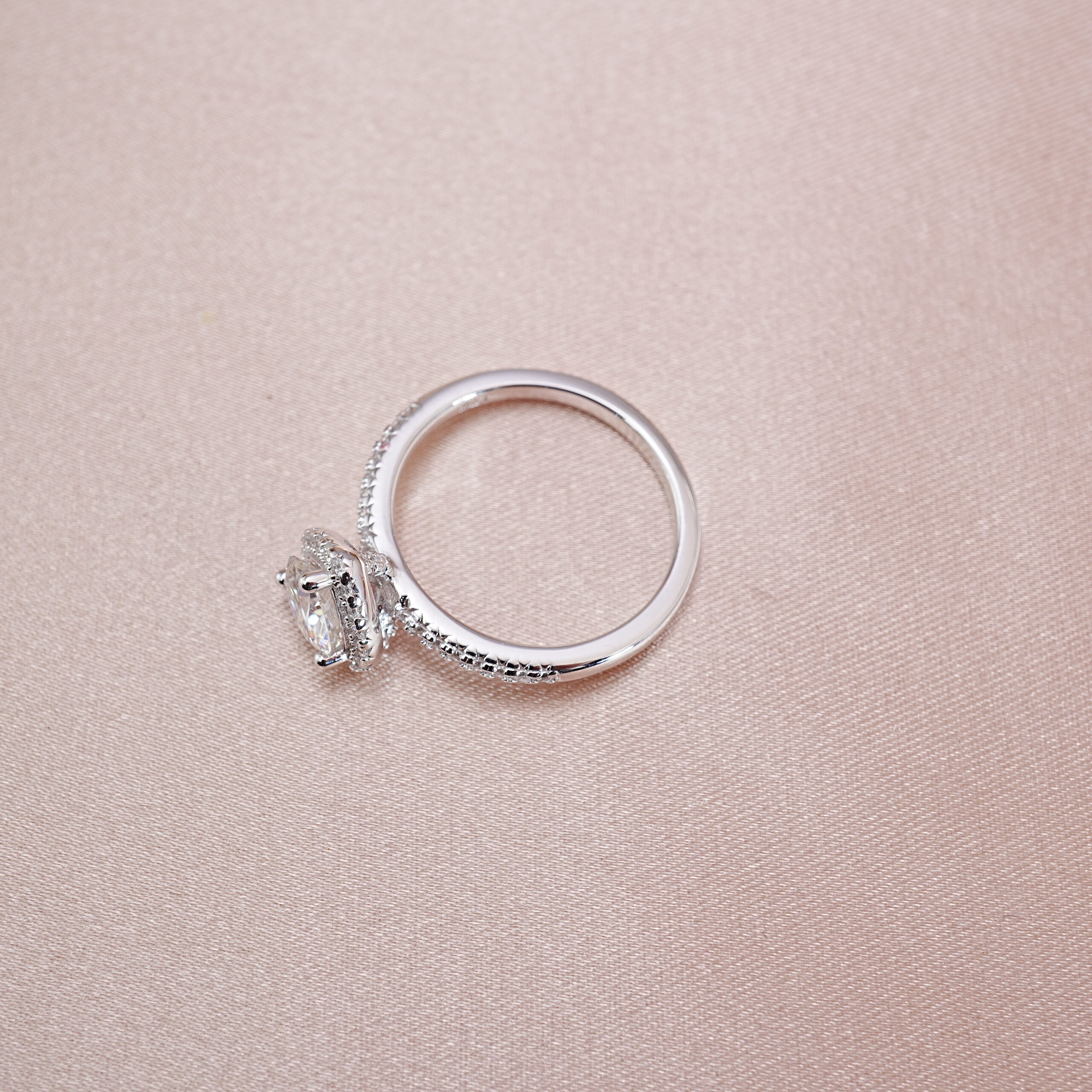 heart-moissanite-halo-s925-silver-ring-main Heart-shaped moissanite halo ring in S925 silver displayed on a soft pink background
