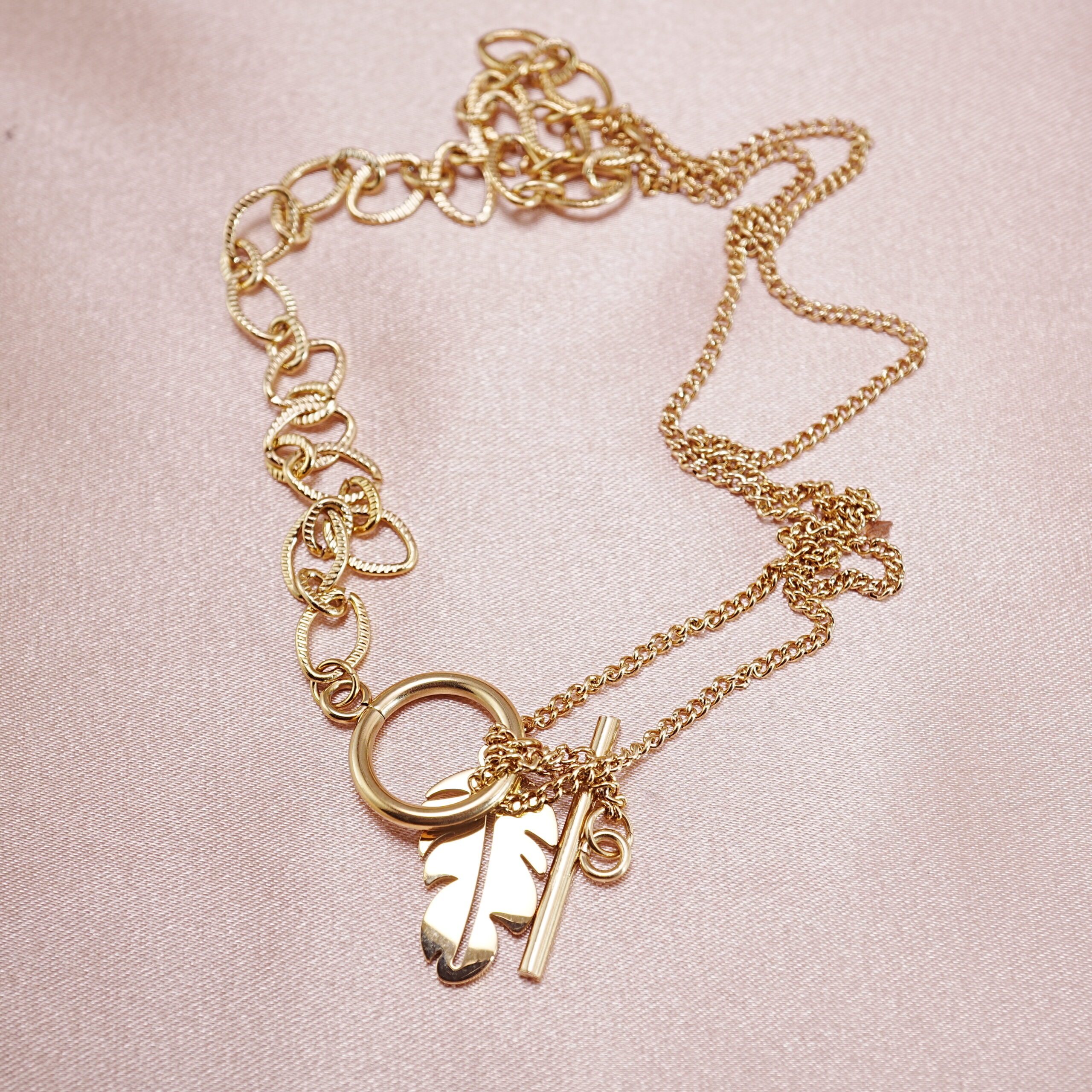 leaf-toggle-chain-necklace-main.jpg gold tone toggle chain necklace with leaf pendant laid flat