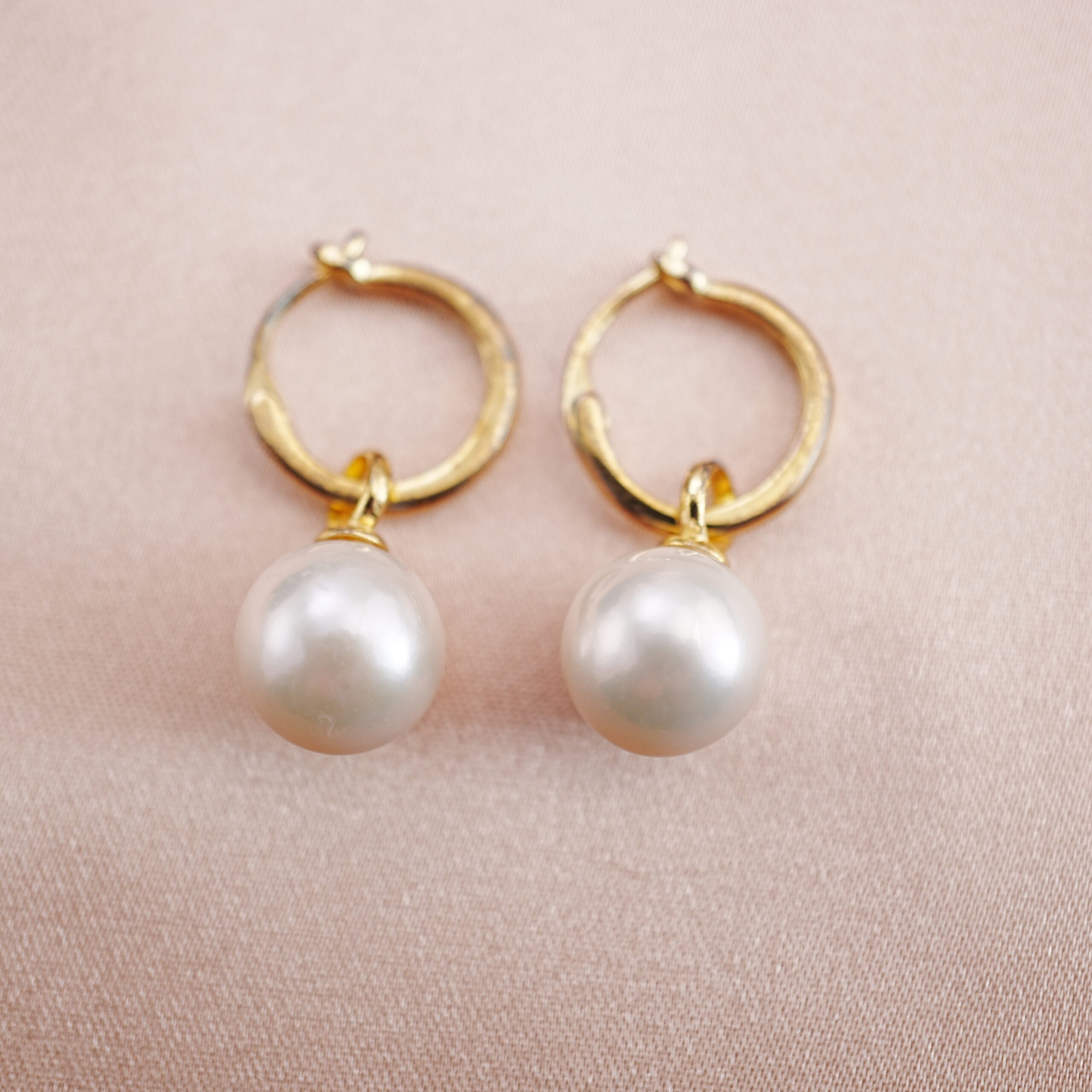 pearl-drop-hoop-earrings-main.jpg Elegant pearl drop hoop earrings on soft pink background