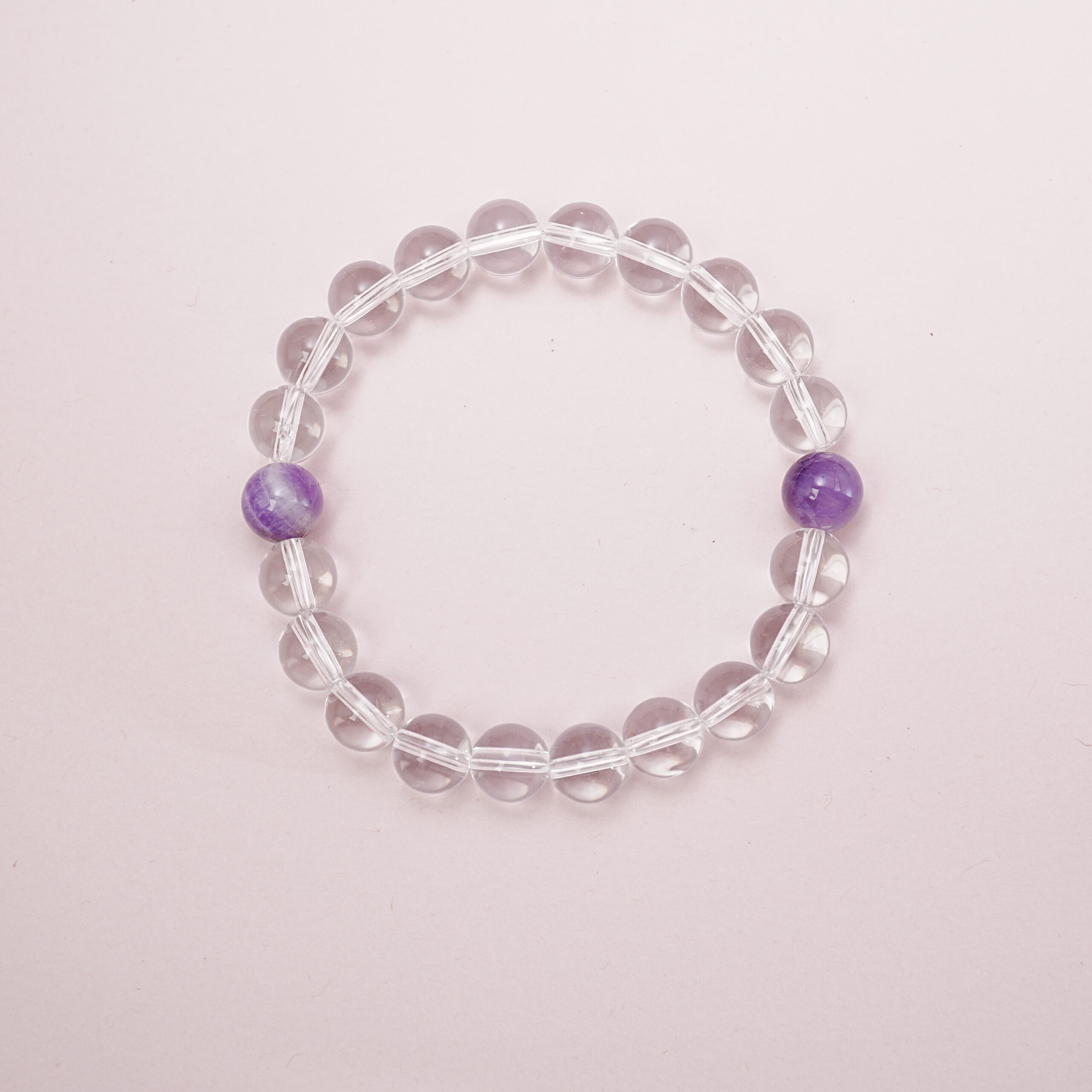 clear-quartz-amethyst-duo-bead-bracelet-main.jpg Clear quartz bracelet with two amethyst accent beads – main product image.
