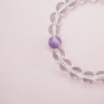 Close-up detail of the amethyst bead on clear quartz bracelet.