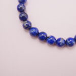 Close-up of polished lapis lazuli beads showing natural golden flecks.