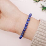 Lapis lazuli beaded bracelet worn on the wrist, showing its deep blue shine.
