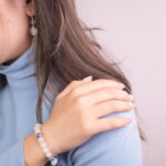 A model wearing the Moonstone and Kyanite bracelet along with the Clear Quartz earrings, presenting a peaceful and elegant look that complements any outfit.