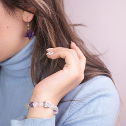 A model wearing the Rose Quartz, Amethyst, and Green Aventurine bracelet paired with Amethyst Merkaba earrings. The soft and calming colors of the set create a harmonious and stylish look.