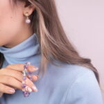 A model wearing the Amethyst and Quartz bracelet and purple embroidered earrings. The bracelet's soothing colors and the earrings' intricate design complete the elegant look.