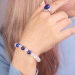 A model wearing the Lapis Lazuli and Moonstone bracelet on their wrist, paired with the Lapis Lazuli ring on their finger. The set creates a balanced and elegant look that enhances any outfit.