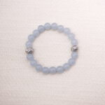Main image of a bracelet made with smooth aquamarine round beads and two textured silver spacers.