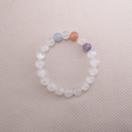 White Moonstone beaded bracelet with pastel accent gemstones on a soft beige background.