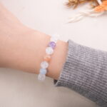 White Moonstone bracelet with light blue, peach, and purple beads shown on wrist.