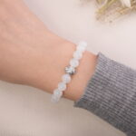 Moonstone and black obsidian bracelet worn on the wrist, showing the silver accent bead.