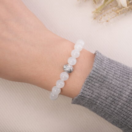 Moonstone and black obsidian bracelet worn on the wrist, showing the silver accent bead.
