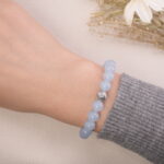 Front view of an aquamarine beaded bracelet worn on the wrist, highlighting its soft blue tones.