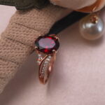 Rose gold ruby ring with oval gemstone displayed in a styled jewelry scene