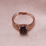 Close-up view of oval ruby ring in rose gold with sparkling accent stones