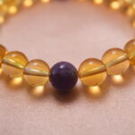 Close-up of citrine beads with amethyst detail, highlighting natural crystal clarity and warm energy.