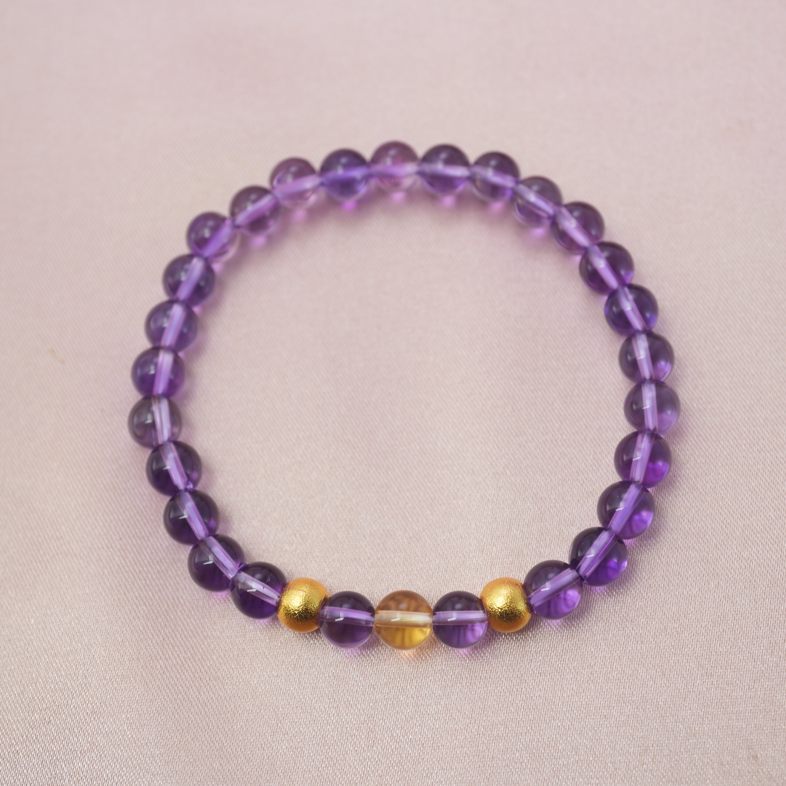 methyst-citrine-harmony-bracelet-main.jpg Amethyst and citrine crystal bracelet with golden accent beads symbolizing balance, wisdom, and prosperity.