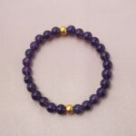 Deep purple amethyst bracelet with golden beads, symbolizing calm energy and inner wisdom.