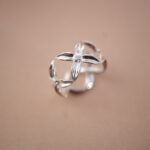 Silver adjustable ring with open floral petal design, symbolizing elegance and renewal.