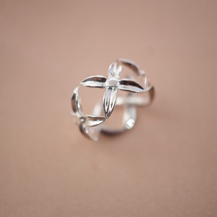 Silver adjustable ring with open floral petal design, symbolizing elegance and renewal.