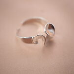 Silver open ring with petal-inspired design, symbolizing elegance and grace.