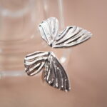 Close-up of butterfly wing silver ring highlighting delicate textures and polished shine.