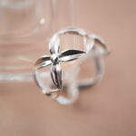 Close-up of silver flower ring highlighting the petal texture and reflective finish.