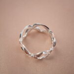 Top view of silver floral ring showing intricate petal pattern and smooth shine.