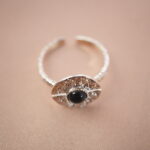Silver evil eye adjustable ring featuring an obsidian center stone for grounding and protection.