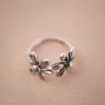 Close-up of silver double daisy ring highlighting its delicate floral petals and smooth texture.