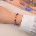 Model wearing the amethyst and citrine bracelet, showing its elegant purple and gold contrast.