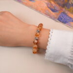 Model wearing citrine bracelet with silver spiral beads, showing a bright and uplifting look.