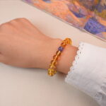 Model wearing citrine and amethyst bracelet, showcasing its bright golden tone and elegant purple accent.