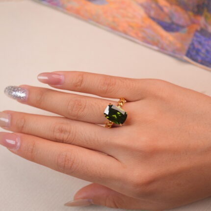 Model wearing a peridot statement ring showing its vibrant green sparkle.