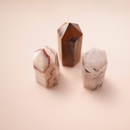 Set of three crystal points – red jasper, tiger’s eye, and tourmalinated quartz – representing grounding and balance.