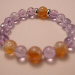 Close-up detail of amethyst and citrine bracelet highlighting the polished surface and the natural color transition between purple and golden tones.1