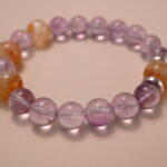 Close-up detail of amethyst and citrine bracelet highlighting the polished surface and the natural color transition between purple and golden tones.2